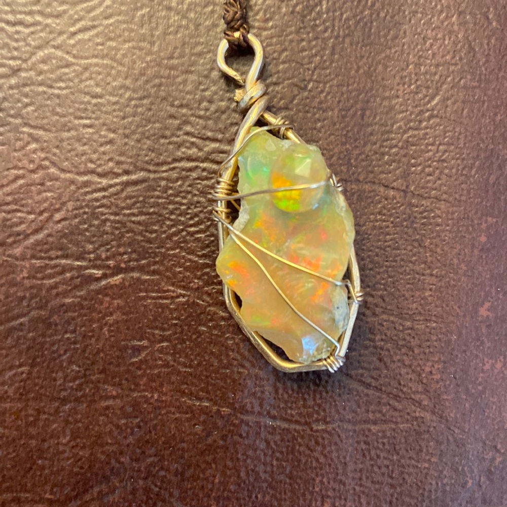 Ethiopian fire opal set in 14k gold filled wire.Hanging on brown silk thread